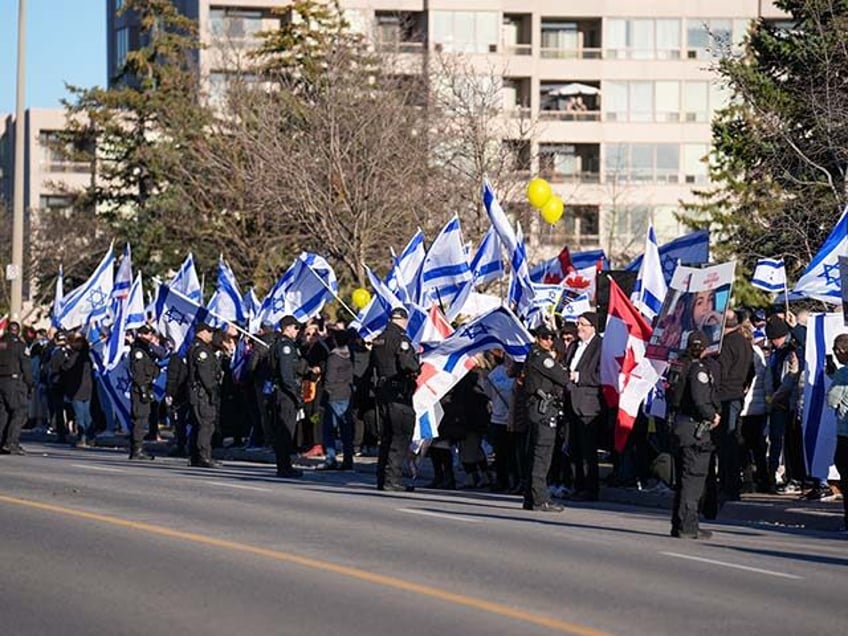 Pro-Israel demonstrators facing pro-Palestinian protestors wave Israeli flags outside Beth