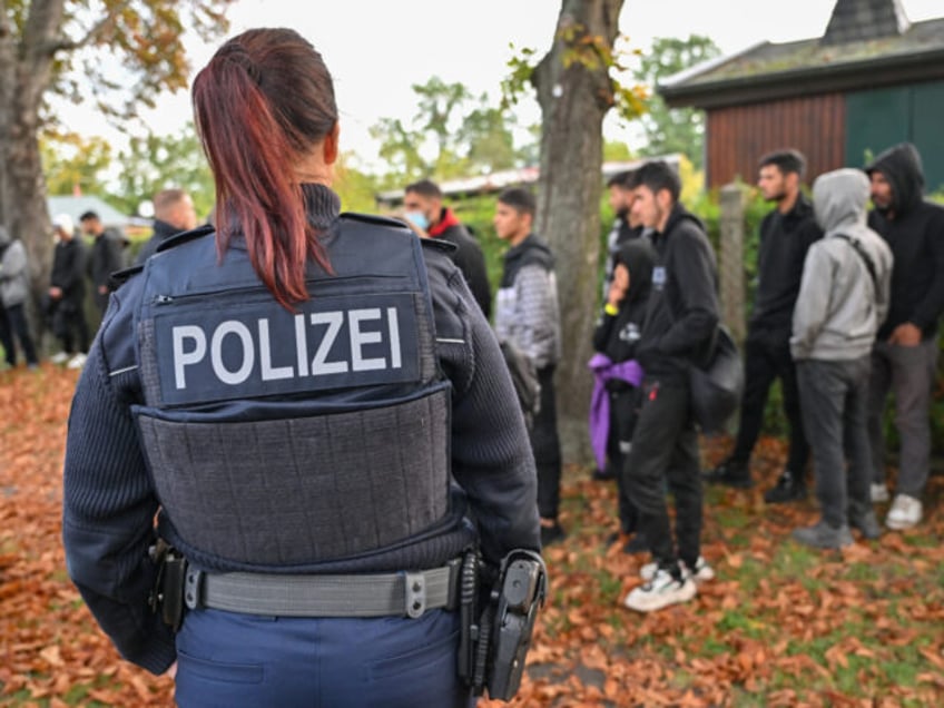 11 October 2023, Brandenburg, Forst: Illegal migrants are guarded by a female officer of the Federal Police during an apprehension near the German-Polish border in Forst (Lausitz). Photo: Patrick Pleul/dpa (Photo by Patrick Pleul/picture alliance via Getty Images)