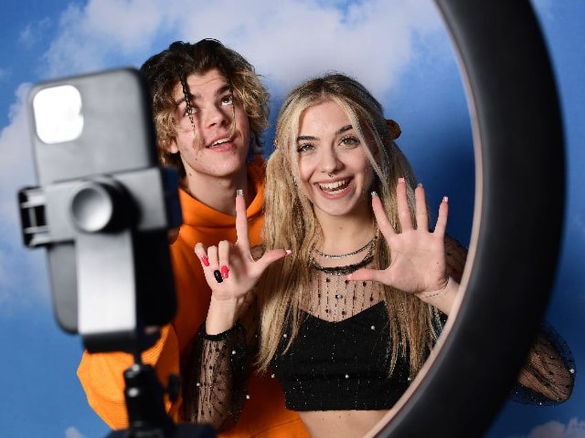 TikTok influencers Florin Vitan (L) and Alessia Lanza perform a video for the social netwo