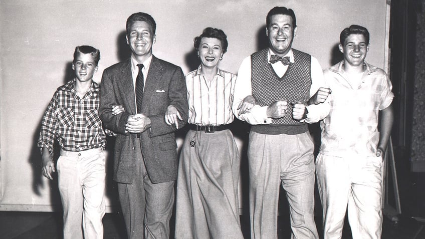 Don DeFore with the Nelson family in arm and smiling.