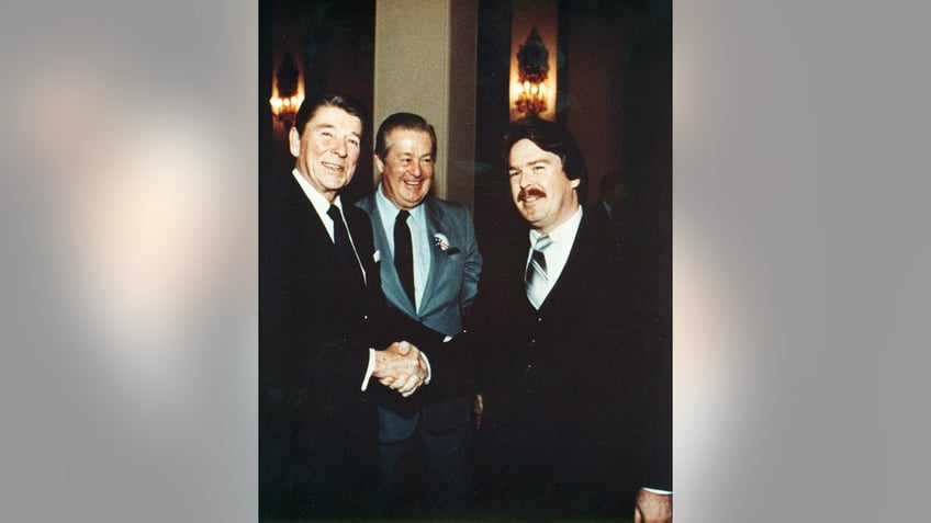 Ron DeFore shaking Ronald Reagans hand as Don DeFore beams