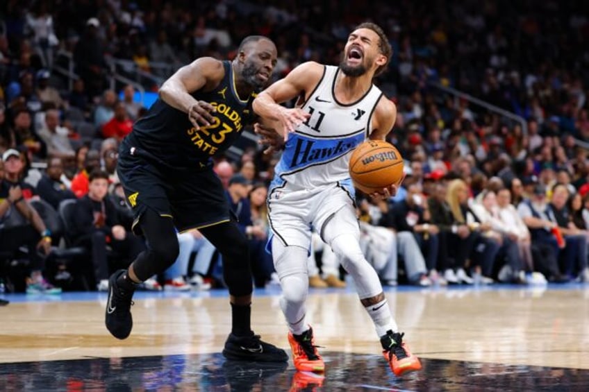 Trae Young of the Atlanta Hawks battles Draymond Green in the Hawks' NBA victory over the