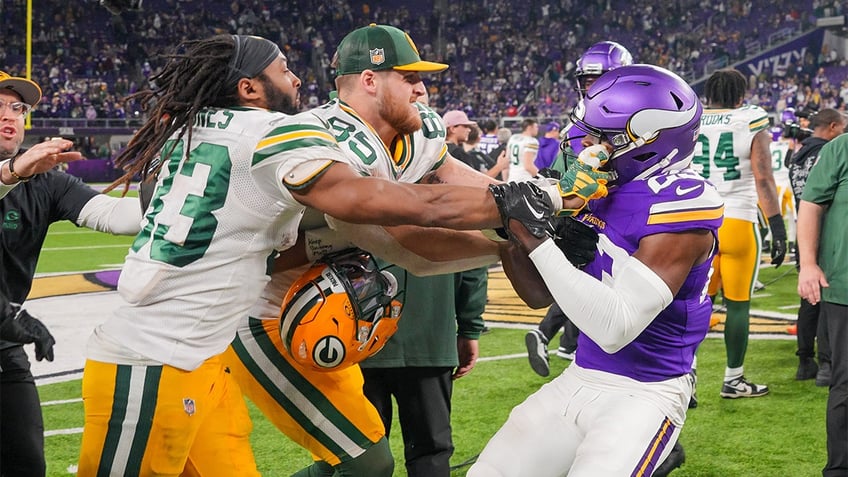 Aaron Jones and Andrew Booth Jr. push each other