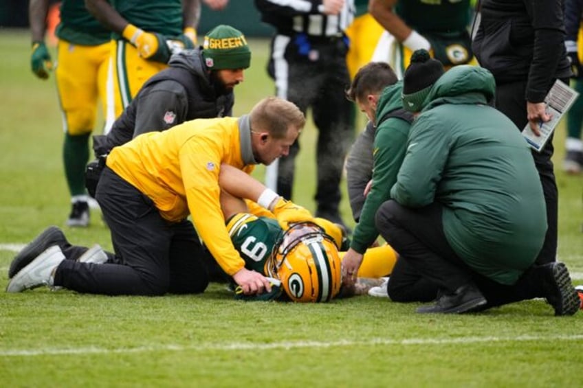 Christian Watson of the Green Bay Packers is attended to after being injured in the second