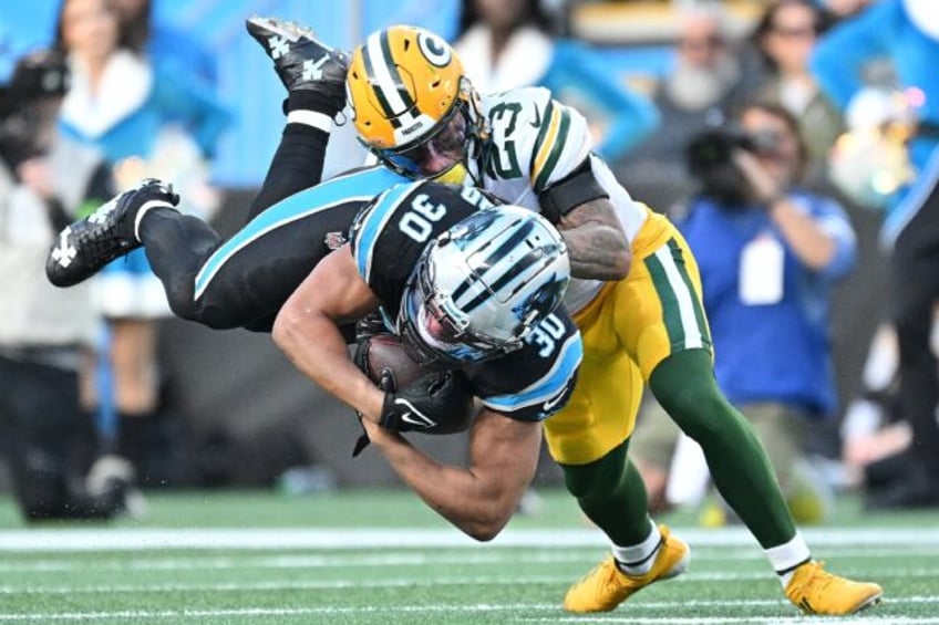 Green Bay Packers cornerback Jaire Alexander tackles Chuba Hubbard of Carolina in the Packers' NFL victory over the Panthers