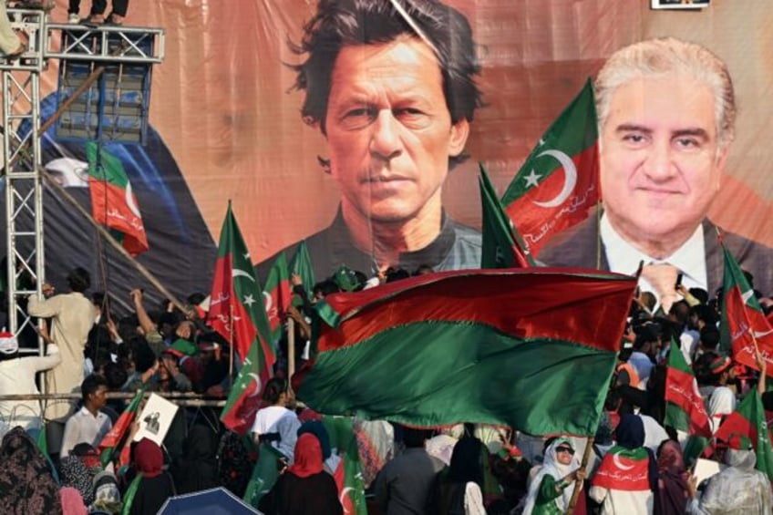 Pakistan Tehreek-e-Insaf supporters wave party flags at a rally outside the capital, Islam