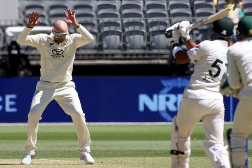 Australia's Nathan Lyon moves out of the way from Pakistan's Abdullah Shafique's shot