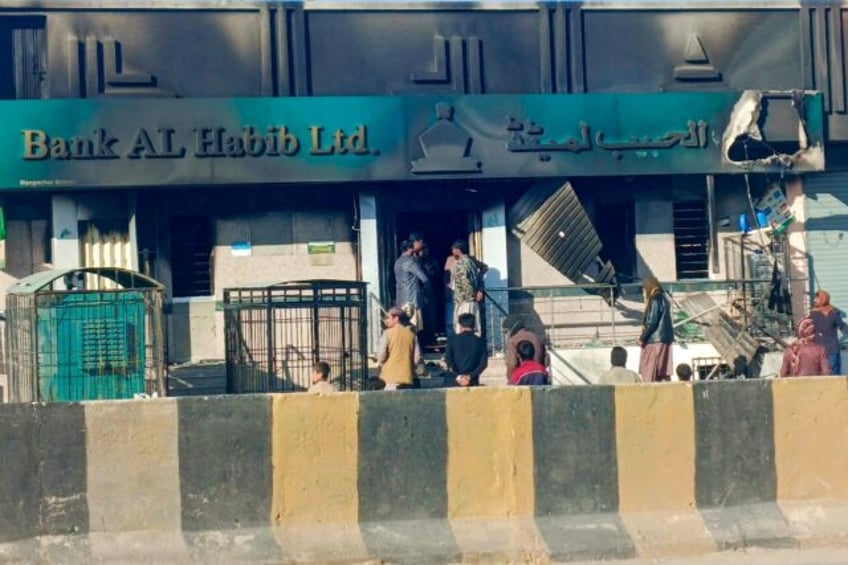 Onlookers gather near a bank set ablaze by militants at Kalat district, in Pakistan's Balo