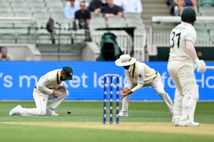 Pakistan's Abdullah Shafique (L) drops a catch from Australian batsman David Warner (R)