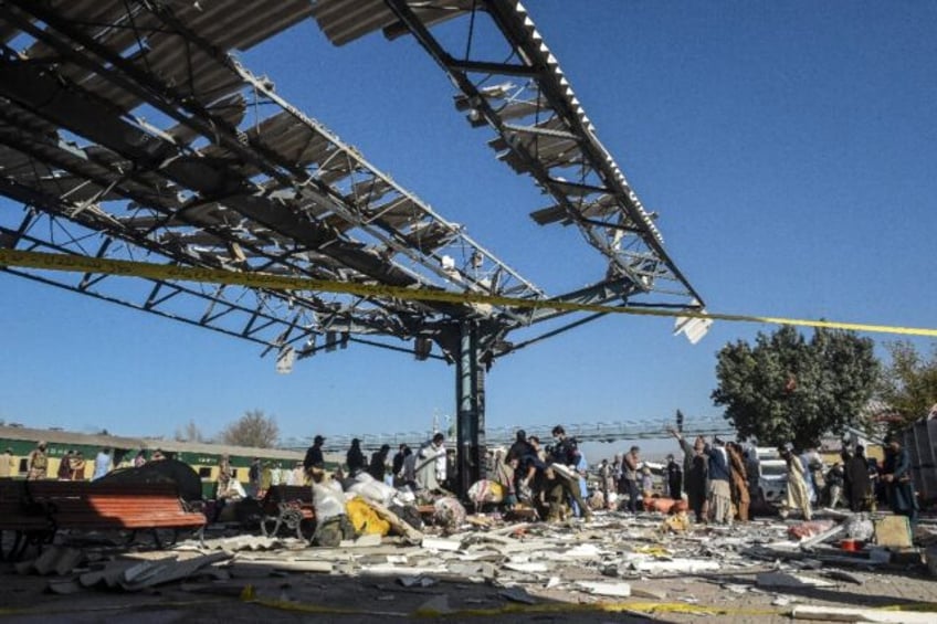 Security personnel inspect the blast site after an explosion at a railway station in Quett