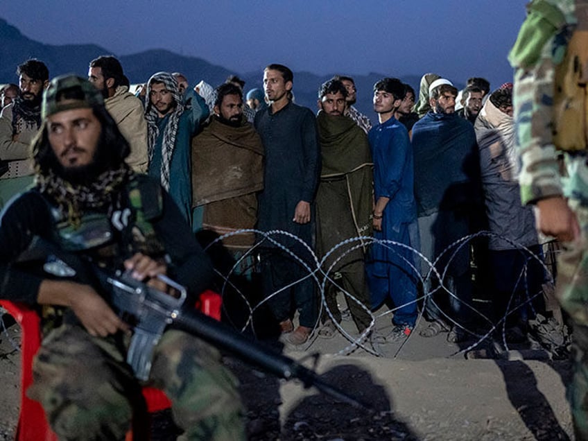 Taliban fighters stand guard as Afghan refugees line up to register in a camp near the Torkham Pakistan-Afghanistan border in Torkham, Afghanistan, Saturday, Nov. 4, 2023. A huge number of Afghans refugees entered the Torkham border to return home hours before the expiration of a Pakistani government deadline for those …