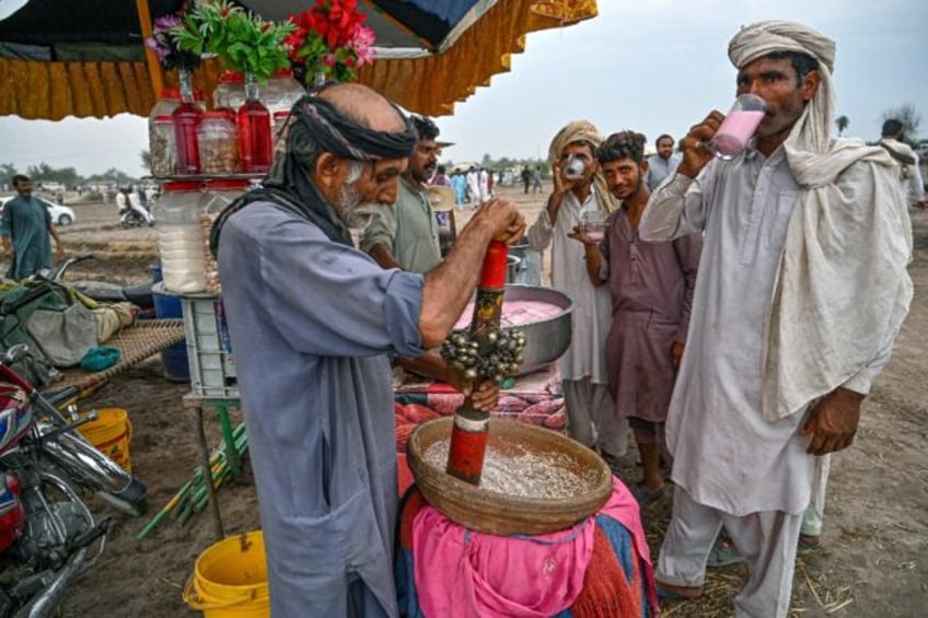 Visitors drink cold beverages at a stall during an annual Sufi mela, or carnival, banned f