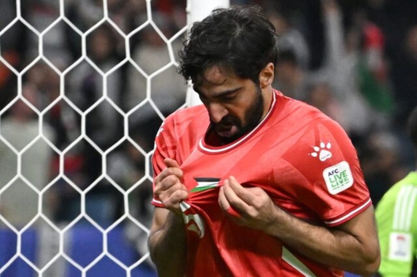 Palestine's defender Mohammed Saleh looks at his jersey