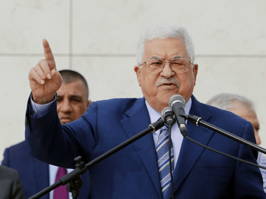 Palestinian President Mahmoud Abbas, center, speaks after laying a wreath at the tomb of l