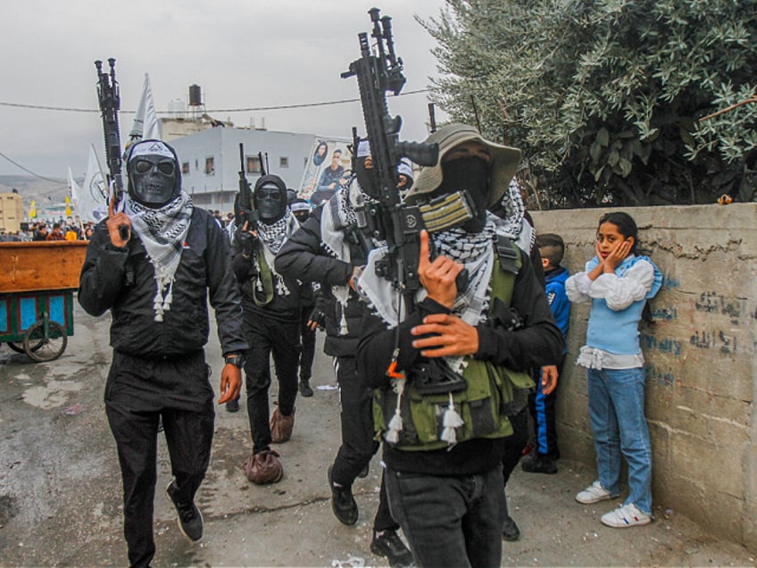 NABLUS, WEST BANK, PALESTINE - 2022/12/24: Masked Palestinian gunmen from the Al-Aqsa Martyrs Brigades of the Fatah movement led by President Mahmoud Abbas, appear carrying their weapons during the demonstration for the Palestinians who were shot dead by the Israeli army this year, in Balata refugee camp, east of Nablus, in the occupied West Bank. (Photo by Nasser Ishtayeh/SOPA Images/LightRocket via Getty Images)