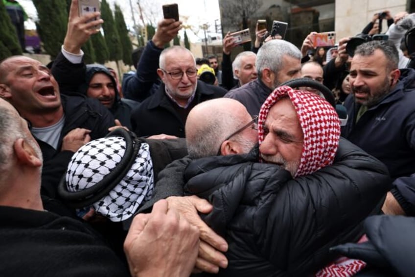 A former Palestinian prisoner hugs a member of his family in the occupied West Bank city o