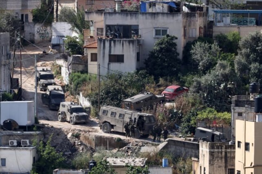 Israeli soldiers line up during a raid in the Nur Shams refugee camp in the occupied West