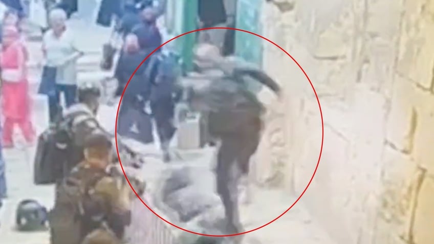 palestinian woman kicked knocked to ground after trying to stab israeli police officer in jerusalem