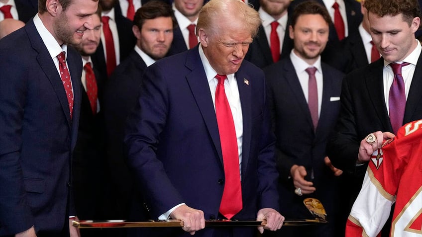 Trump holds a gold hockey stick