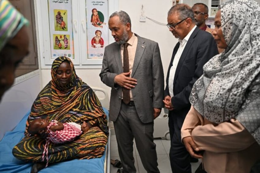 World Health Organization (WHO) Director-General Tedros Adhanom Ghebreyesus (C) visits a c