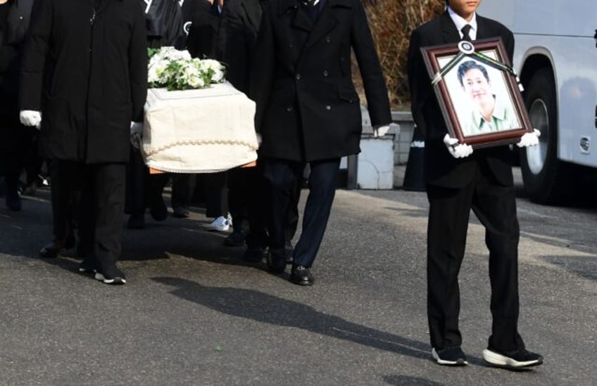 Mourners carry a portrait of the late South Korean actor Lee Sun-kyun after his funeral ceremony in Seoul