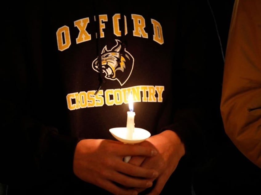 A student holds a candle during a vigil after a shooting at Oxford High School at Lake Pointe Community Church in Lake Orion, Michigan on November 30, 2021. - A 15-year-old student opened fire at his Michigan high school on November 30, killing three teenagers and wounding eight other people before surrendering to police, authorities said, in what was the deadliest US school shooting so far this year.