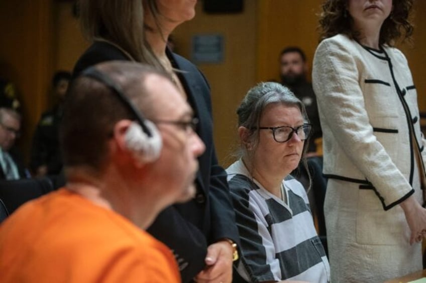 James Crumbley (L in orange) and his wife, Jennifer Crumbley (R in black-and-white stripes