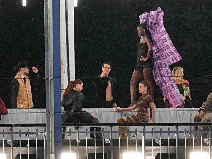 Models walk during a fashion show over the Seine River bridge in Paris, France, at the ope