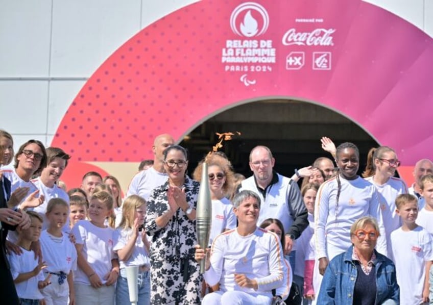 Former French wheelchair fencer Emmanuelle Assmann holds the Paris Paralympics torch as it