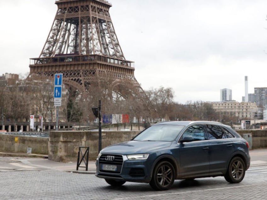 A local resident drives his sport utility vehicle (SUV) in the center of Paris, with the Eiffel Tower seen in the background, on January 30, 2024. On February 4, 2024 Paris' city hall is organizing a vote on the status of the heaviest and most polluting SUVs, and the creation …