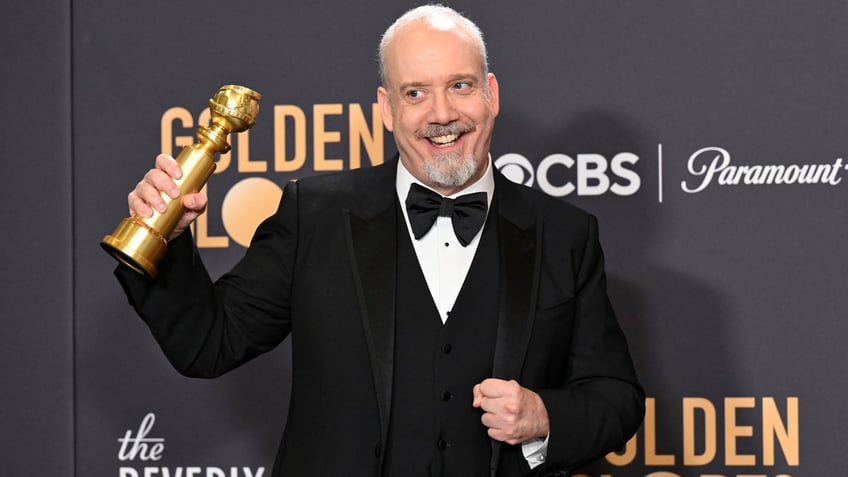 Paul Giamatti holding his Golden Globe award