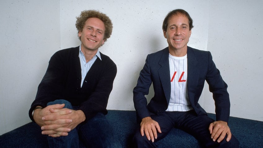 Art Garfunkel and Paul Simon sitting and smiling together