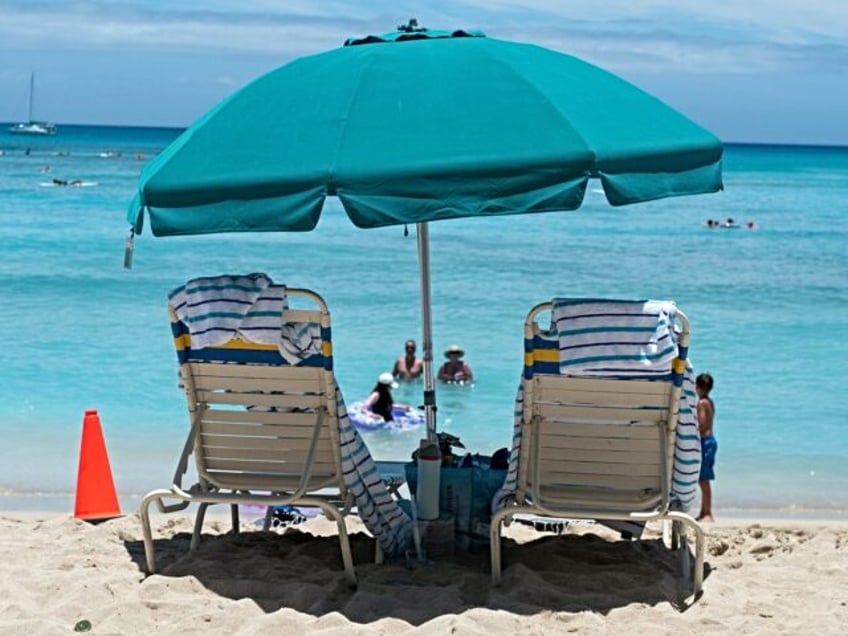 Two beach chairs are visible under an umbrella at Waikiki Beac, island of Oahu, Honolulu,