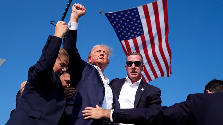 Donald Trump defiantly raising fist after being shot