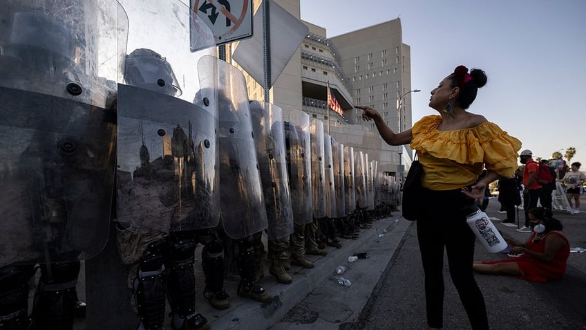 Protester angrily points at National Guard shield line