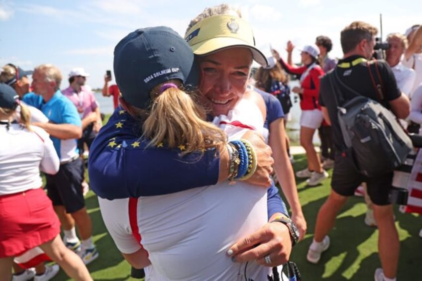 Europe captain Suzann Pettersen, facing front, hugs US captain Stacy Lewis after the Ameri