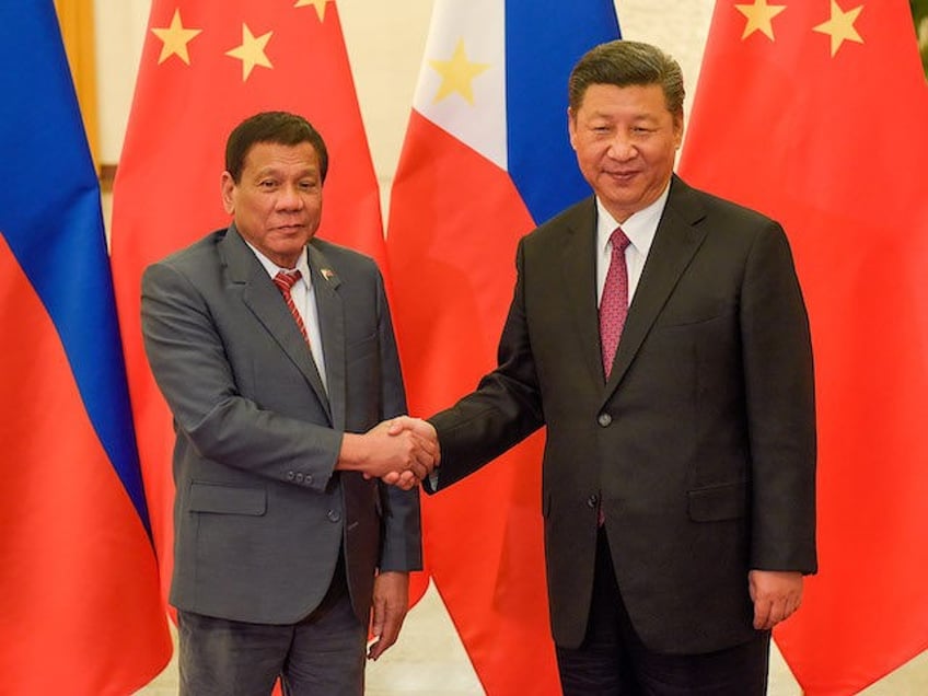 Chinese President Xi Jinping (R) shakes hands with Philippines President Rodrigo Duterte (