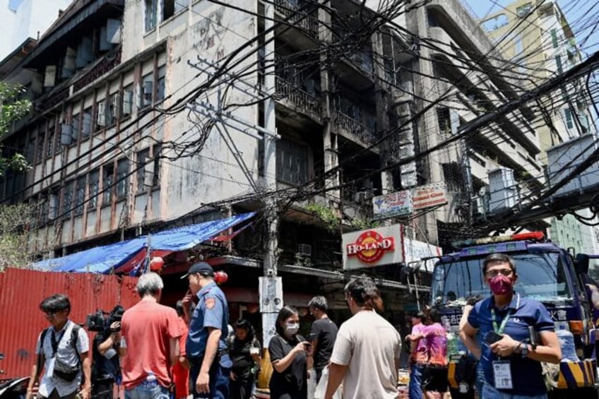 A crowd gathers People, policemen, and media personnel at the scene of the fire in Manila'