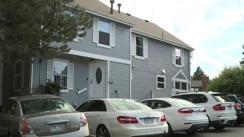 Gray home with white cars parked outside.