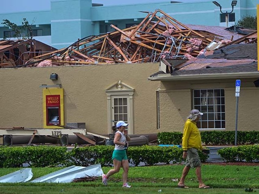 People walk past a Wells Fargo bank branch that was destroyed by the intense tornado that