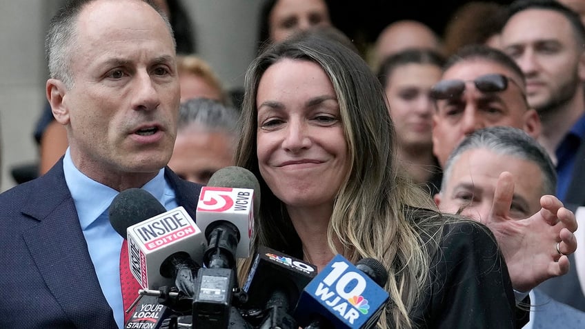 Karen Read smiles as defense attorney David Yannett speaks to reporters in front of Norfolk Superior Court