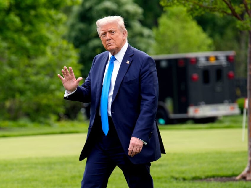 US President Donald Trump walks on the South Lawn of the White House before boarding Marin