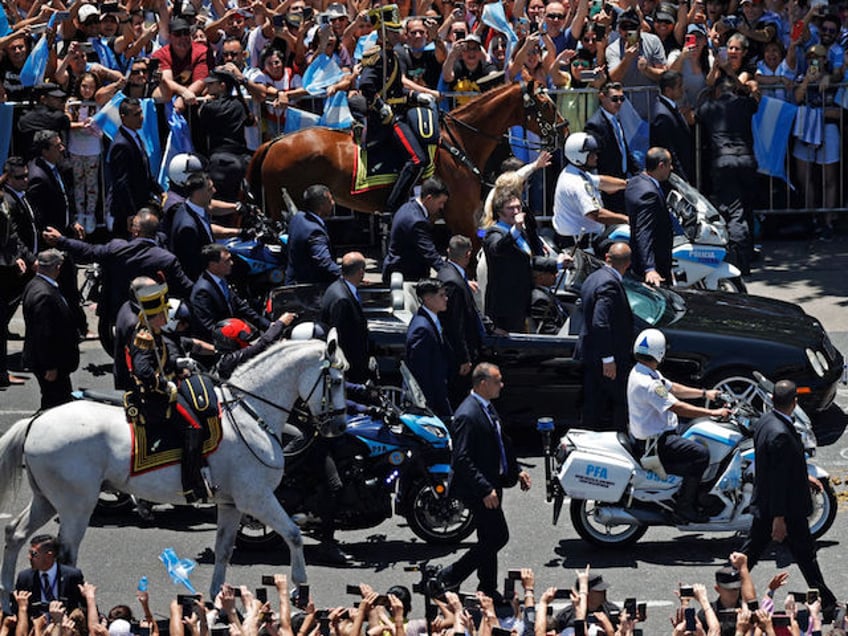 Argentina's new president Javier Milei waves at supporters as he heads to Casa Rosada Presidential Palace after being sworn in during an inauguration ceremony at the Congress in Buenos Aires on December 10, 2023. Libertarian economist Javier Milei was sworn in Sunday as Argentina's president, after a resounding election victory fuelled by fury over the country's economic crisis. (Photo by Emiliano LASALVIA / AFP)