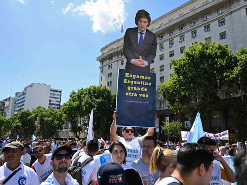 A supporter of Argentina's President-elect Javier Milei holds a banner that reads "Make Argentina great again" near the Congress, where Milei's inauguration ceremony will take place, in Buenos Aires on December 10, 2023. Libertarian economist Javier Milei was sworn in Sunday as Argentina's president, after a resounding election victory fueled by fury over the country's economic crisis. "I swear to God and country... to carry out with loyalty and patriotism the position of President of the Argentine Nation," he said as he took the oath of office, before outgoing President Alberto Fernandez placed the presidental sash over his shoulders. (Photo by Luis ROBAYO / AFP)