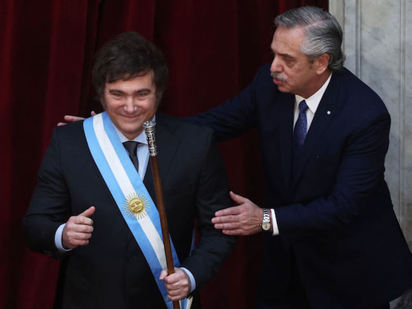 Argentina's new president Javier Milei (L) gestures after receiving the presidential sash and baton from outgoing president Alberto Fernandez during his inauguration ceremony at the Congress in Buenos Aires on December 10, 2023. Libertarian economist Javier Milei was sworn in Sunday as Argentina's president, after a resounding election victory fueled by fury over the country's economic crisis. "I swear to God and country... to carry out with loyalty and patriotism the position of President of the Argentine Nation," he said as he took the oath of office, before outgoing President Alberto Fernandez placed the presidental sash over his shoulders. (Photo by ALEJANDRO PAGNI / AFP)