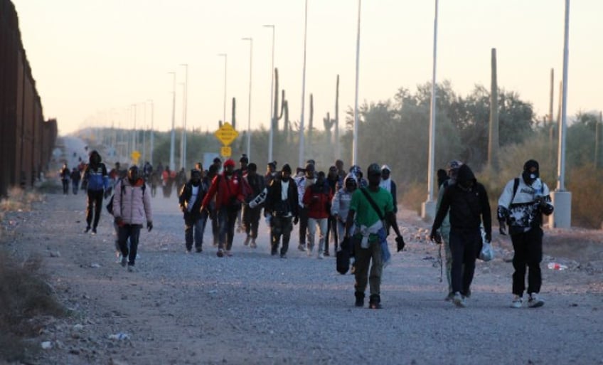 Migrant march along Lukeville border wall. (Randy Clark/Breitbart Texas)