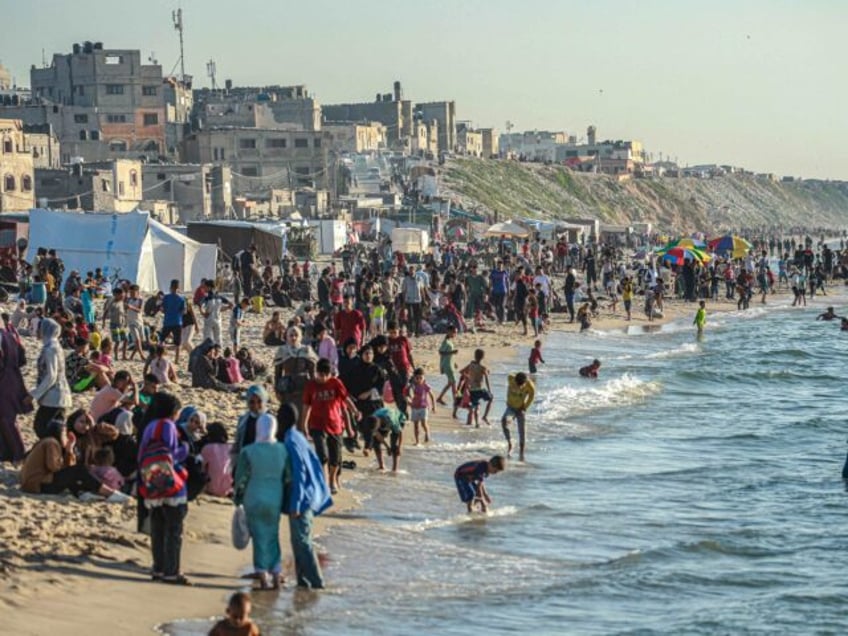 TOPSHOT - Palestinians gather on the beach in Deir el-Balah in the central Gaza Strip on A