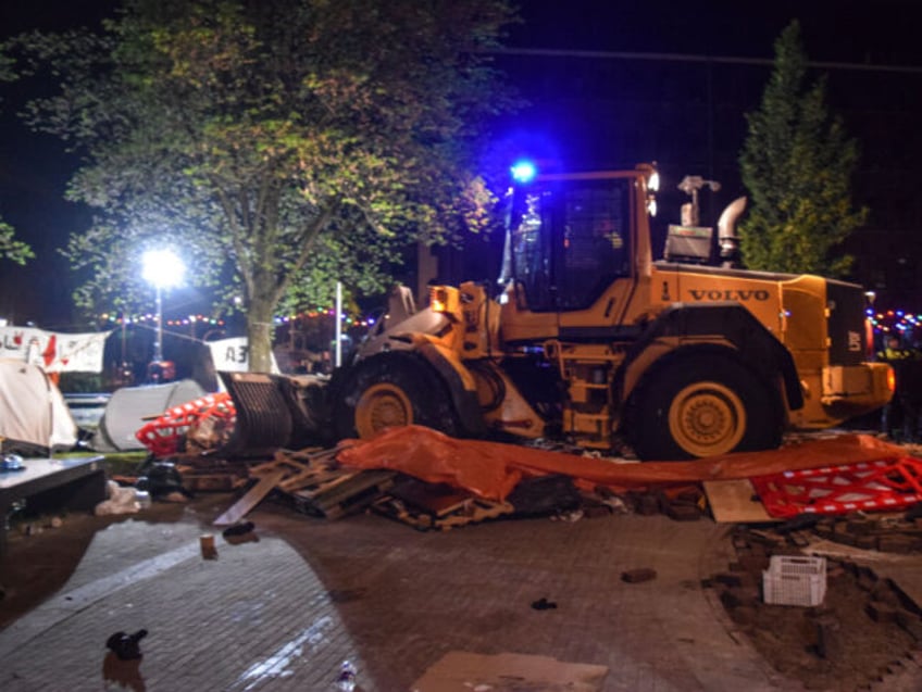 AMSTERDAM, THE NETHERLANDS - MAY 7: A bulldozer destroy tents as police mobile unit interv