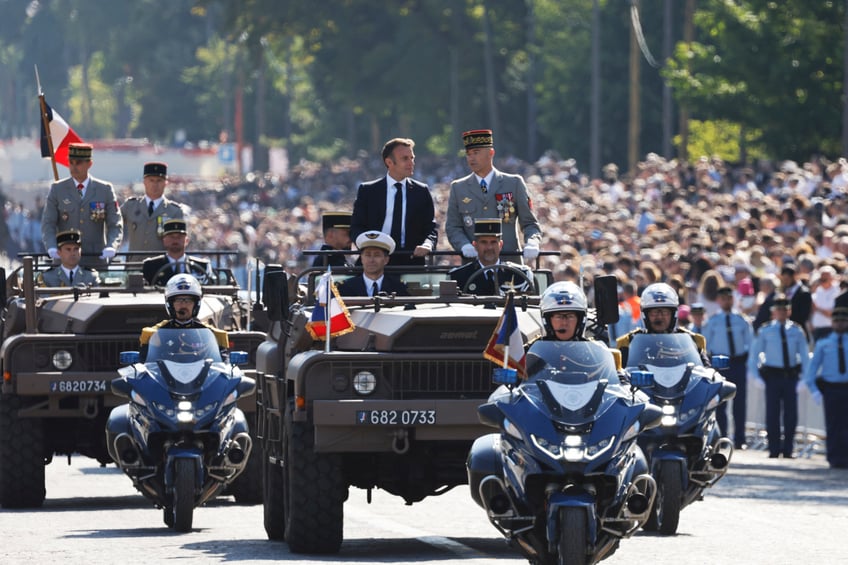 France's President Emmanuel Macron (Top-L) stands in the command car flanked by Chief of Staff of the Armed Forces (CEMA), Thierry Burkhard (Top-R) during the Bastille Day military parade on the Avenue Foch, in Paris on July 14, 2024. (Photo by Ludovic MARIN / AFP) (Photo by LUDOVIC MARIN/AFP via Getty Images)