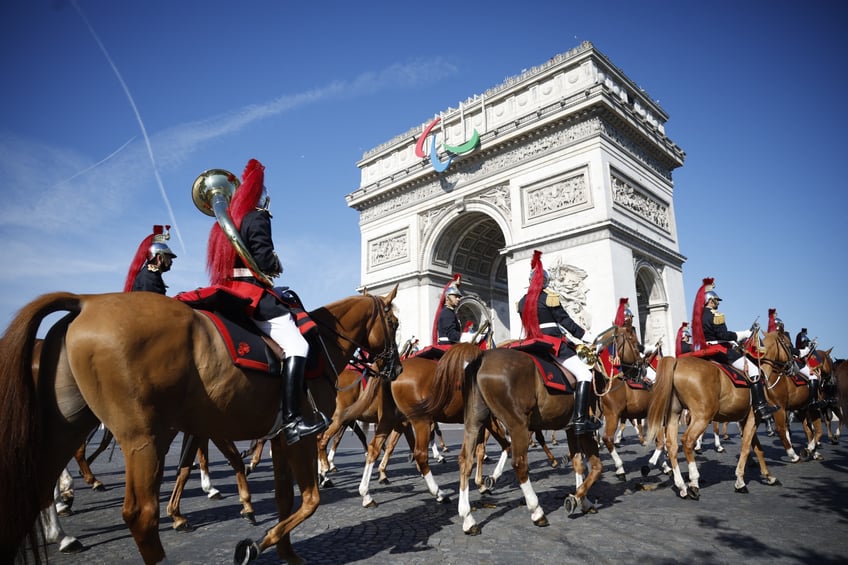 The cavalry Regiment of the French Republican Guard arrive to prepare for the Bastille Day military parade on the Avenue Foch, with the Arc de Triomphe in the background in Paris on July 14, 2024. (Photo by Yoan VALAT / POOL / AFP) (Photo by YOAN VALAT/POOL/AFP via Getty Images)